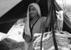 A Pakistani Hindu Refugee Woman Looks Out Of Her Tent, With Food