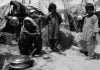 Pakistani Hindu Refugee Woman and Two Children Cooking In The Outdoor Kitchen