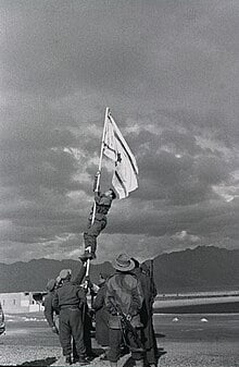 Captain Avraham "Bren" Adan raising the INK FLAG at Um Rashrash, a site now City of Eilat, marking the end of the 1948 Independence War - Wikipedia