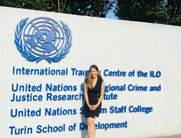Beautiful woman standing by international organization sign.