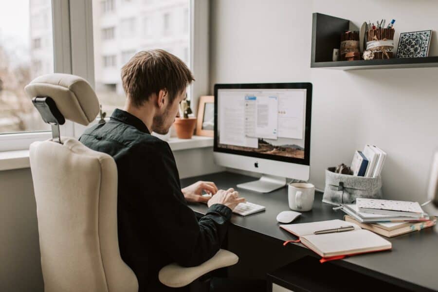 Young professional using computer for cloud management.
