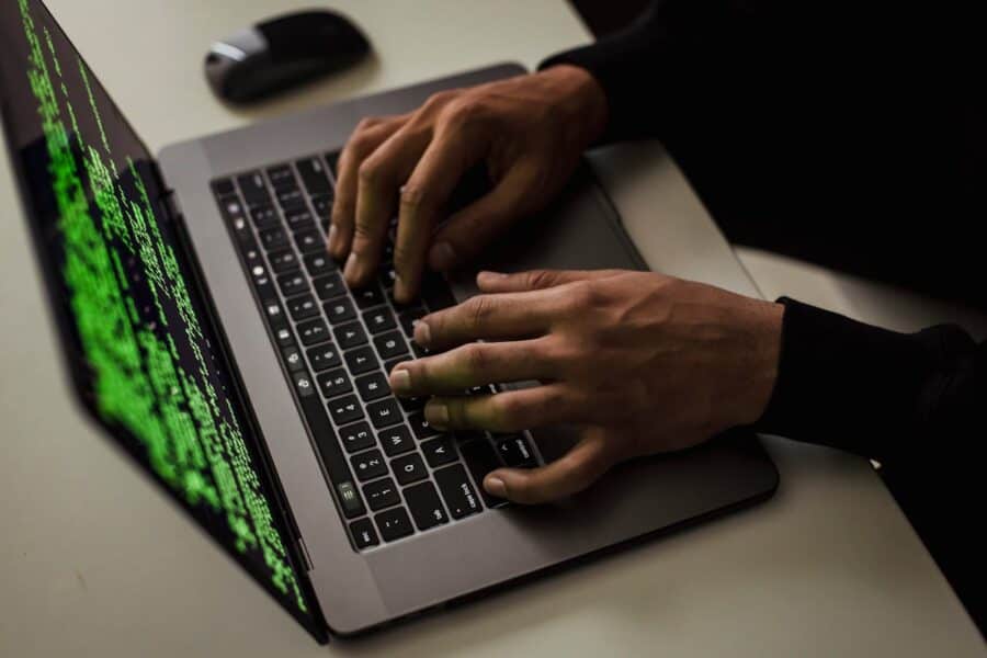man typing on a laptop