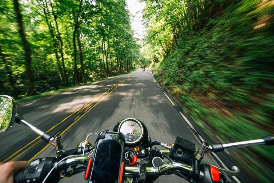 Photo by K : https://www.pexels.com/photo/photo-of-person-riding-motorcycle-on-road-between-trees-2396045/