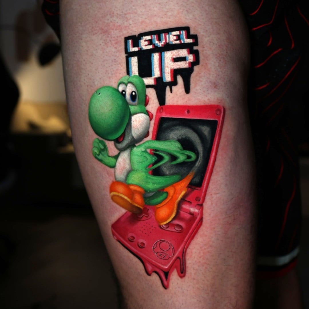 Yoshi tattoo design with "Level Up" text by tattoo artist Natacha "Nacha" Rios