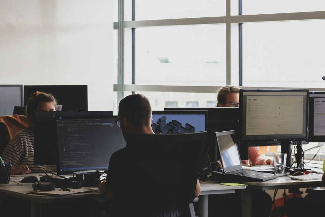 people sitting on chairs while using the computer