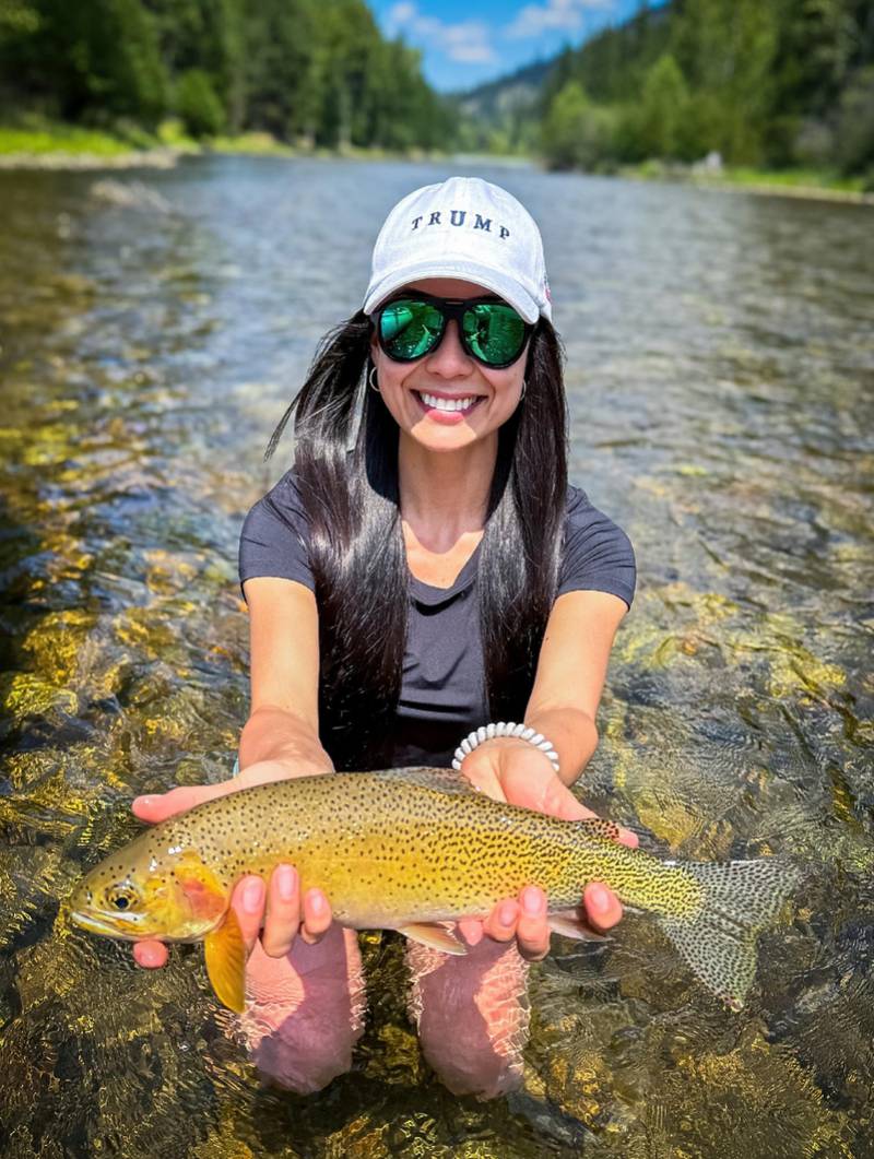 Nathalie Guasis holding a trout in a Montana river